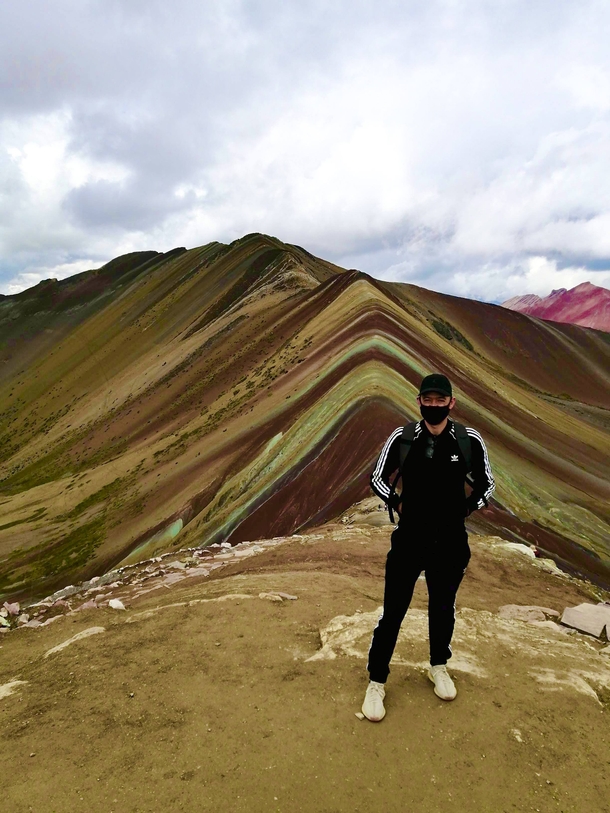 Jay Bittner standing on peak of the photogenic Rainbow Mountain near Cusco, Peru